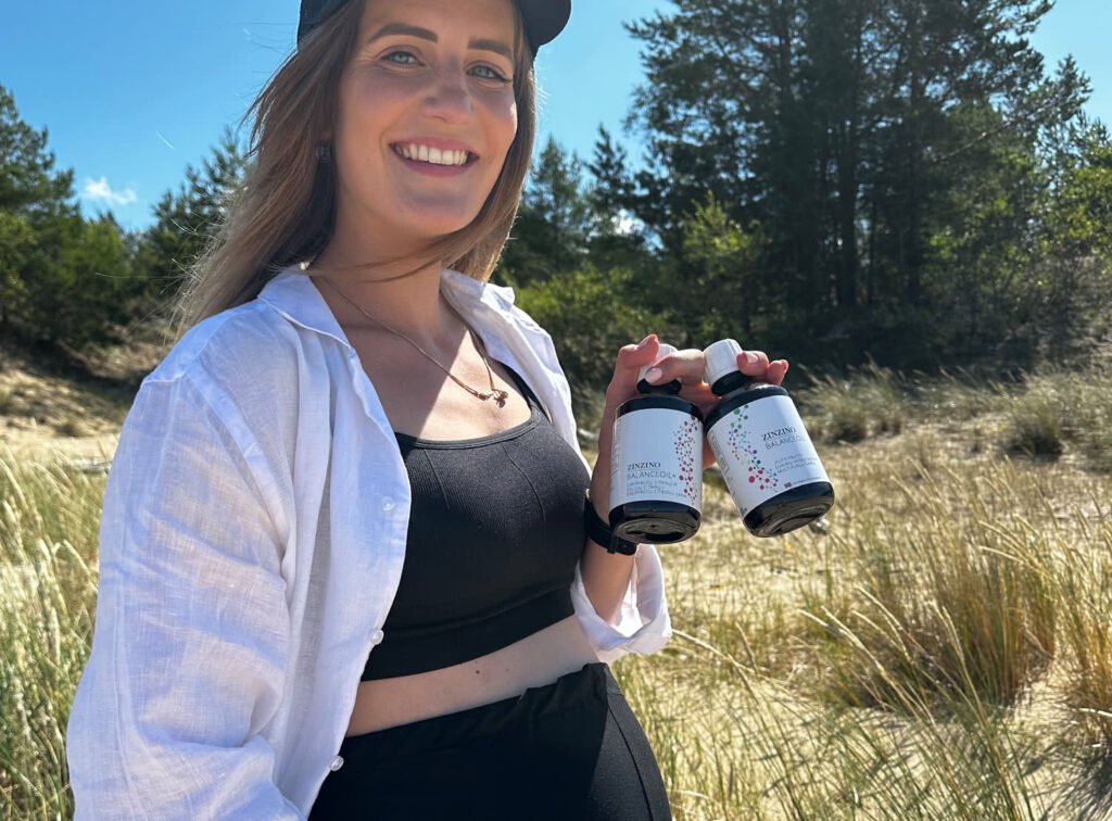 Mujer embarazada sosteniendo dos botes de BalanceOil de Zinzino